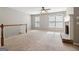 Bright living room featuring a brick fireplace, plush carpet, and neutral walls at 56 American Walk, Peachtree City, GA 30269