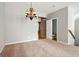 Cozy carpeted living room with chandelier and view to bathroom with tile shower at 56 American Walk, Peachtree City, GA 30269