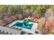 Aerial view of community pool, tennis courts, playground, and clubhouse surrounded by mature trees at 56 American Walk, Peachtree City, GA 30269