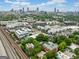 Aerial view of a city neighborhood with modern apartments and green trees in front of a sprawling city skyline at 32 Walthall Ne St # A, Atlanta, GA 30307