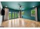 An empty main bedroom with hardwood floors, neutral curtains, and glass doors to an outdoor balcony at 32 Walthall Ne St # A, Atlanta, GA 30307