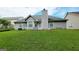 View of home's backyard, featuring a well-maintained lawn and exterior gray siding with a chimney at 5502 Sapphire Cir, Ellenwood, GA 30294