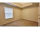 Neutral bedroom featuring a tray ceiling, plush carpet, and a window for natural light at 5502 Sapphire Cir, Ellenwood, GA 30294