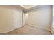 Bedroom with neutral carpet featuring two white doors, an opening for a closet, and base trim at 5502 Sapphire Cir, Ellenwood, GA 30294