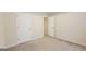 Bedroom with neutral carpet featuring two white doors, an opening for a closet, and base trim at 5502 Sapphire Cir, Ellenwood, GA 30294