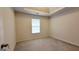 Neutral bedroom featuring a tray ceiling, plush carpet, and a window for natural light at 5502 Sapphire Cir, Ellenwood, GA 30294