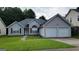 Charming gray home featuring a two-car garage and a well-manicured front lawn at 5502 Sapphire Cir, Ellenwood, GA 30294