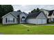 Inviting gray home with an attached garage and a lush green lawn at 5502 Sapphire Cir, Ellenwood, GA 30294