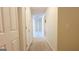 A hallway with neutral carpet leads to other rooms, with white doors and neutral walls at 5502 Sapphire Cir, Ellenwood, GA 30294