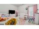 Bright bedroom with a white crib, pink accents, and a large television at 3711 Wartrace Dr, South Fulton, GA 30331