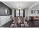 Modern dining room featuring a glass table, velvet chairs, dark hardwood floors, and a striking black accent wall at 3711 Wartrace Dr, South Fulton, GA 30331