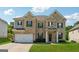 Two-story brick home featuring a manicured lawn, two-car garage, and a welcoming front porch with black shutters at 3711 Wartrace Dr, South Fulton, GA 30331
