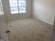 Cozy bedroom with large window and neutral carpet flooring at 1238 Polk Xing, Mcdonough, GA 30252