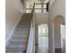 Inviting foyer with staircase featuring wood railing and an open view to the upstairs landing at 1238 Polk Xing, Mcdonough, GA 30252