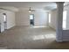 Open living room area with neutral carpet, large windows, and a ceiling fan at 1238 Polk Xing, Mcdonough, GA 30252