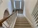 View of the carpeted staircase leading to the front door, with wood railings and white risers at 1238 Polk Xing, Mcdonough, GA 30252