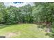 Expansive backyard, featuring plenty of green space surrounded by dense trees at 4023 Anvil Block Rd, Ellenwood, GA 30294