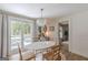 Dining area with a white oval table, modern light fixture, and sliding glass doors to a patio with a table and chairs at 4023 Anvil Block Rd, Ellenwood, GA 30294