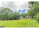 Single-story home with a beautiful lawn and covered parking in the front yard area at 4023 Anvil Block Rd, Ellenwood, GA 30294