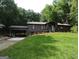 Charming single-story home with a lush lawn and covered carport nestled among mature trees at 4023 Anvil Block Rd, Ellenwood, GA 30294