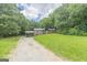 Beautiful front yard of single-story home with large grassy area and plenty of mature trees for shade at 4023 Anvil Block Rd, Ellenwood, GA 30294