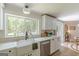 Bright kitchen featuring a farmhouse sink, modern cabinetry, and a large window offering a view of the trees outside at 4023 Anvil Block Rd, Ellenwood, GA 30294