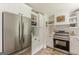 Modern kitchen with stainless steel appliances, white cabinets, tile backsplash, and decorative floating shelves at 4023 Anvil Block Rd, Ellenwood, GA 30294
