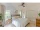 Bright main bedroom featuring neutral décor, plush bedding, a ceiling fan, and natural light from the large windows at 4023 Anvil Block Rd, Ellenwood, GA 30294