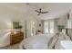 Tastefully designed bedroom features a wooden dresser, poster, natural lighting, a ceiling fan, and plush bedding at 4023 Anvil Block Rd, Ellenwood, GA 30294