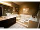 Bathroom featuring a soaking tub, a skylight, and decorative elements at 155 Granby Ln, Fayetteville, GA 30215