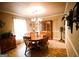 Traditional dining room featuring a wooden table with seating, a classic chandelier, and a wooden china cabinet at 155 Granby Ln, Fayetteville, GA 30215