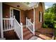 Charming brick front porch with white railings and a black front door at 155 Granby Ln, Fayetteville, GA 30215