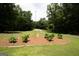 Expansive front yard featuring a circular garden with lush greenery and a long driveway at 155 Granby Ln, Fayetteville, GA 30215