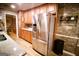 Modern kitchen with stainless steel refrigerator, granite countertops, wooden cabinets, and brick backsplash at 155 Granby Ln, Fayetteville, GA 30215