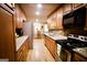 A modern kitchen with stainless steel appliances, wooden cabinetry, and views into the dining area at 155 Granby Ln, Fayetteville, GA 30215