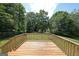 Wooden deck overlooking a large, green backyard with mature trees and a fire pit, great for outdoor living at 634 Skyline Dr, Villa Rica, GA 30180