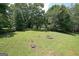 Expansive backyard featuring lush green grass, mature trees, a charming fire pit area, and plenty of space at 634 Skyline Dr, Villa Rica, GA 30180