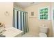 Well-lit bathroom featuring a shower with striped curtain, a white vanity and toilet at 595 Mcgarity Dr, Mcdonough, GA 30252