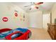 Themed ' bedroom featuring a race car bed, ceiling fan, and colorful decor at 595 Mcgarity Dr, Mcdonough, GA 30252