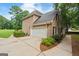 Rear view of brick home with two-car garage, complemented by manicured landscaping at 595 Mcgarity Dr, Mcdonough, GA 30252