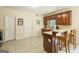 Open kitchen area with tile flooring, wood cabinets, and bar seating with views to the dining area at 595 Mcgarity Dr, Mcdonough, GA 30252