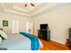 Comfortable main bedroom with tray ceiling, hardwood floors, dark furniture, and a cozy ambiance at 595 Mcgarity Dr, Mcdonough, GA 30252