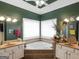 Bright bathroom features dual sinks and a luxurious soaking tub with tiled backsplash at 141 Wexford Ct, Stockbridge, GA 30281