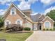 Two-story stucco home with arched entryway, attached garage, and a well-maintained landscaped front yard at 141 Wexford Ct, Stockbridge, GA 30281