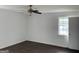 Bright bedroom featuring a ceiling fan, fresh white walls, and dark wood-look flooring at 276 Oakland Rd, Mcdonough, GA 30253