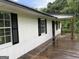 Side view of home featuring a spacious wooden deck and white siding with black shutters at 276 Oakland Rd, Mcdonough, GA 30253