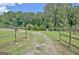 Charming entrance with a wooden gate leading to a gravel driveway and picturesque property at 460 Morgan Mill Rd, Brooks, GA 30205
