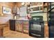 Rustic kitchen with black appliances and colorful, repurposed wooden cabinets at 460 Morgan Mill Rd, Brooks, GA 30205