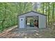 View of metal outbuilding with open bay door featuring an open-style interior and lawn equipment storage at 460 Morgan Mill Rd, Brooks, GA 30205