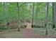 Picturesque path through a wooded area featuring a rustic bridge crossing a gentle stream at 460 Morgan Mill Rd, Brooks, GA 30205